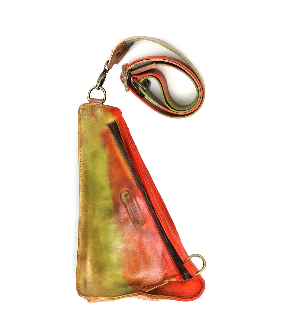 The Adept by Bed Stu is a triangular-shaped sling bag crafted from sustainable leather, featuring multi-colored hues of vibrant red, green, and brown. It includes a zipper and an adjustable strap.
