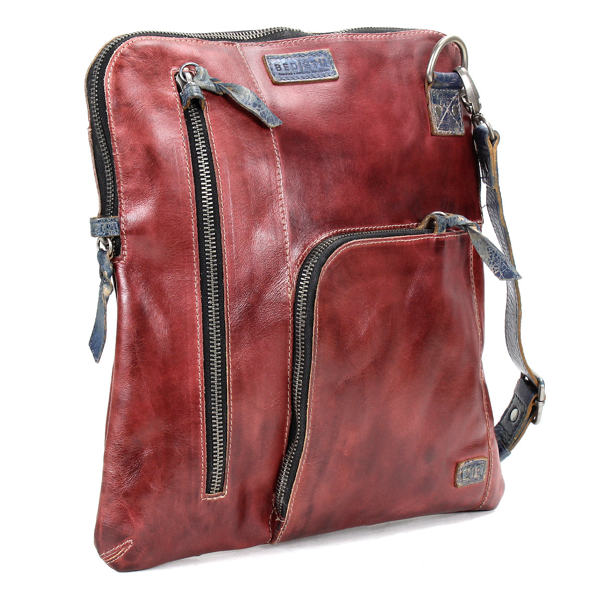 The Bed Stu Aiken is a square-shaped, brown leather convertible crossbody bag featuring two front zippered pockets and an adjustable strap.
