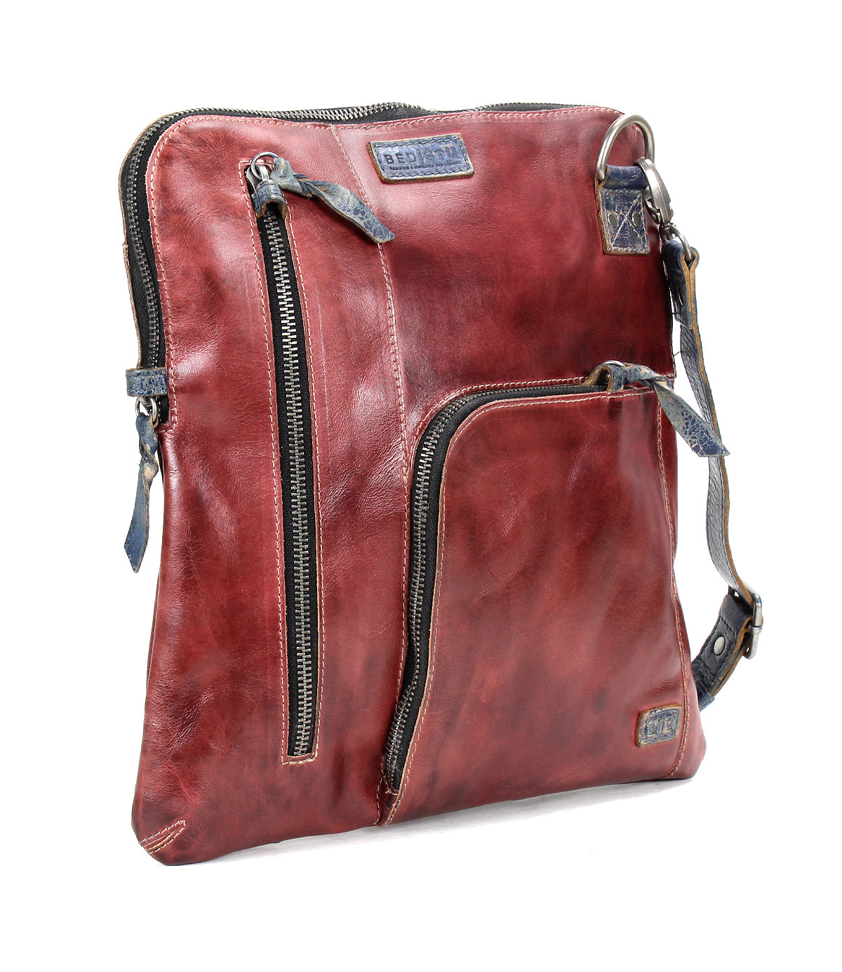 The Bed Stu Aiken is a square-shaped, brown leather convertible crossbody bag featuring two front zippered pockets and an adjustable strap.