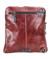The Bed Stu Aiken is a square brown leather convertible crossbody bag featuring a front zipper pocket, two metal corner rings, a vertical center seam, and an adjustable strap for versatile carrying options.