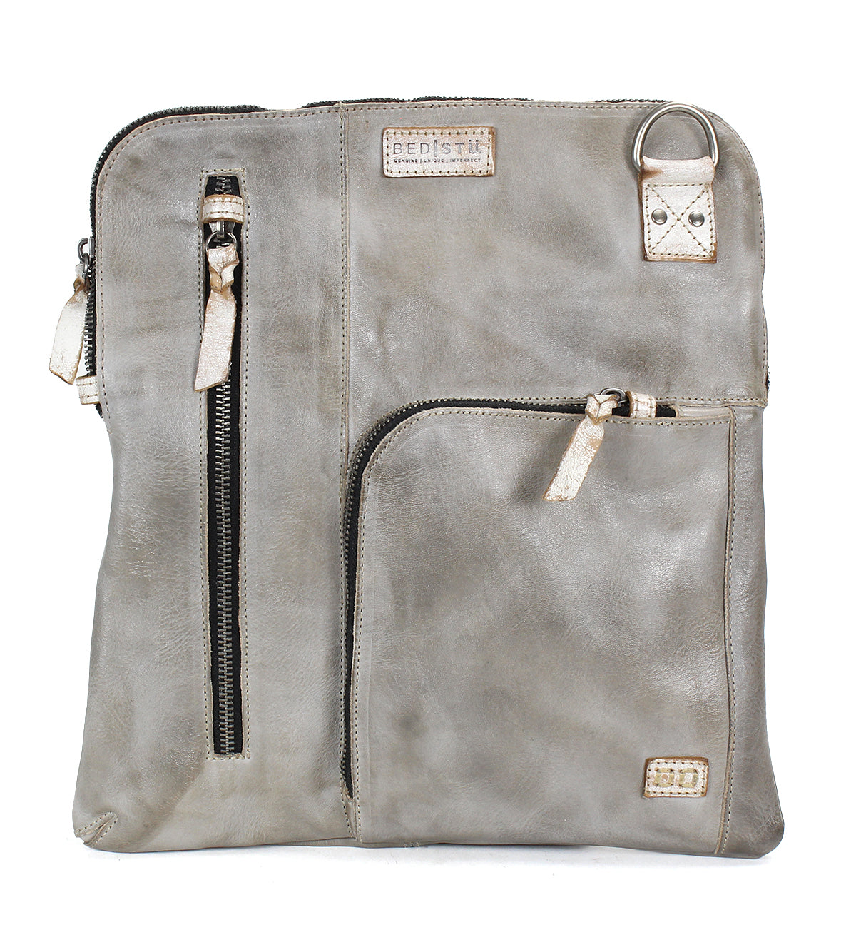 Introducing the Aiken by Bed|Stü—a square crossbody crafted from light gray full-grain leather, featuring two zippered pockets on the front, a small patch label, and a silver D-ring near the top right corner. The adjustable strap ensures comfortable and versatile wear.