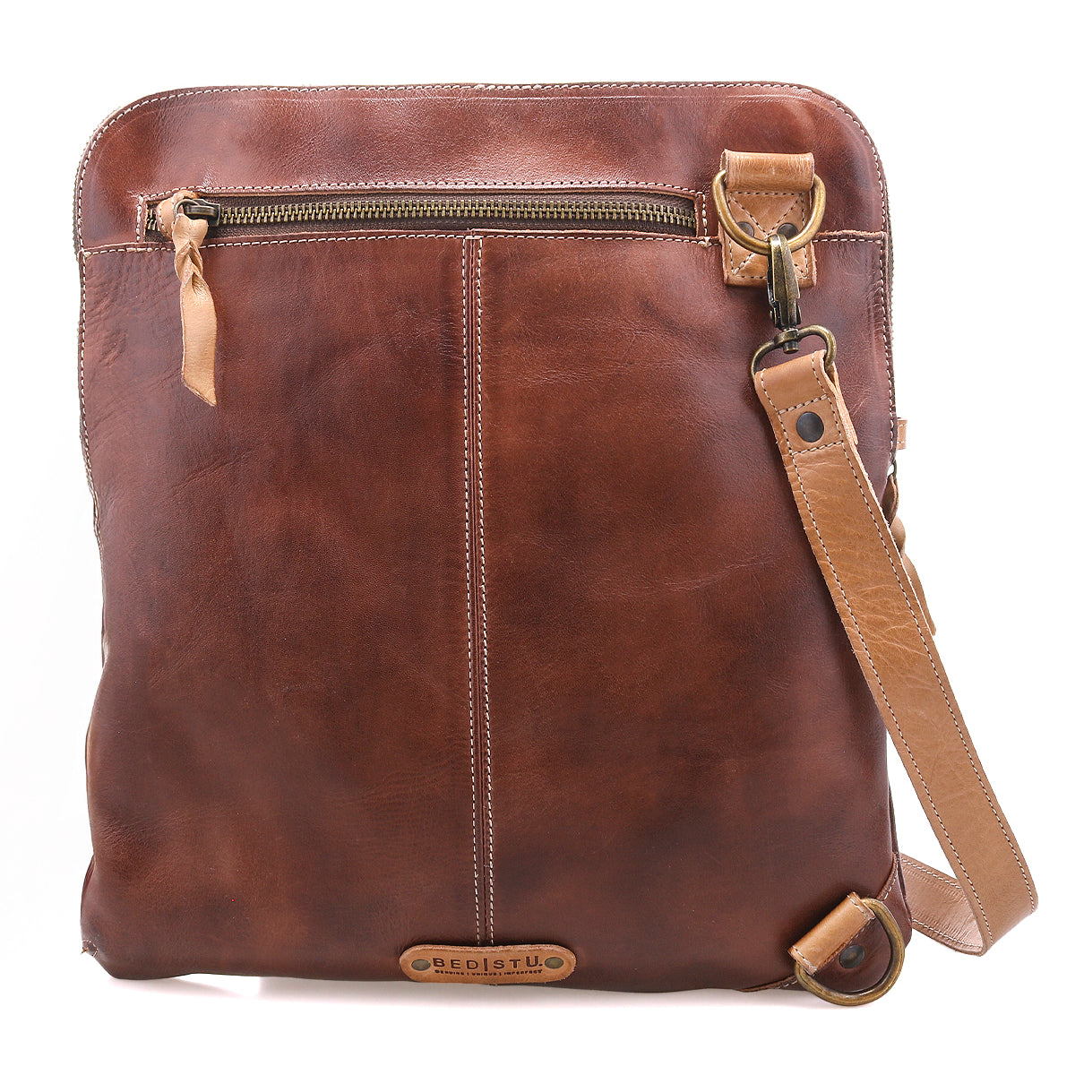 The Bed Stu Aiken is a brown full-grain leather crossbody bag featuring a front zipper pocket, adjustable strap, and visible stitching details.