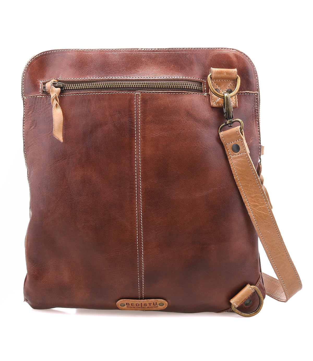 The Bed Stu Aiken is a brown full-grain leather crossbody bag featuring a front zipper pocket, adjustable strap, and visible stitching details.