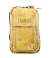 The Alelike by Bed Stu is a stylish mustard yellow leather pouch with a front flap, visible stitching, and a zipper. Crafted from premium leather, it features "Bed Stu" embossed on the front and is perfect for use as an on-the-go crossbody phone holder.
