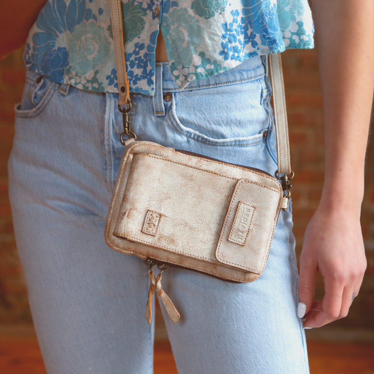 A woman wearing premium leather jeans and a Bed Stu purse, Bed Stu cell phone holder.