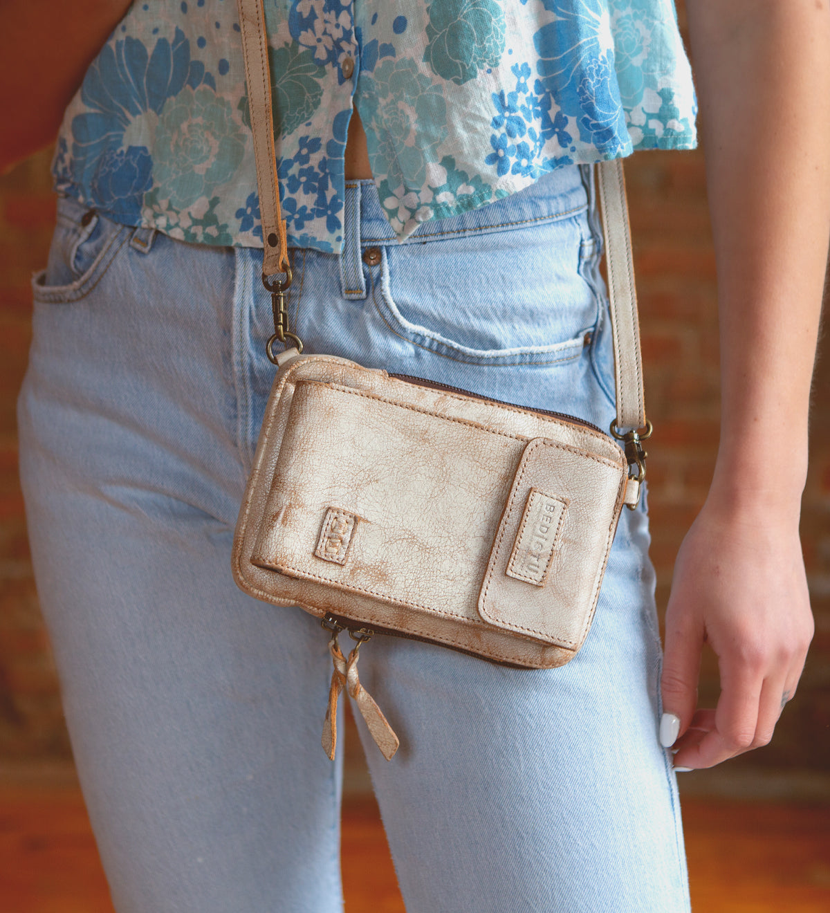 A woman wearing premium leather jeans and a Bed Stu purse, Bed Stu cell phone holder.