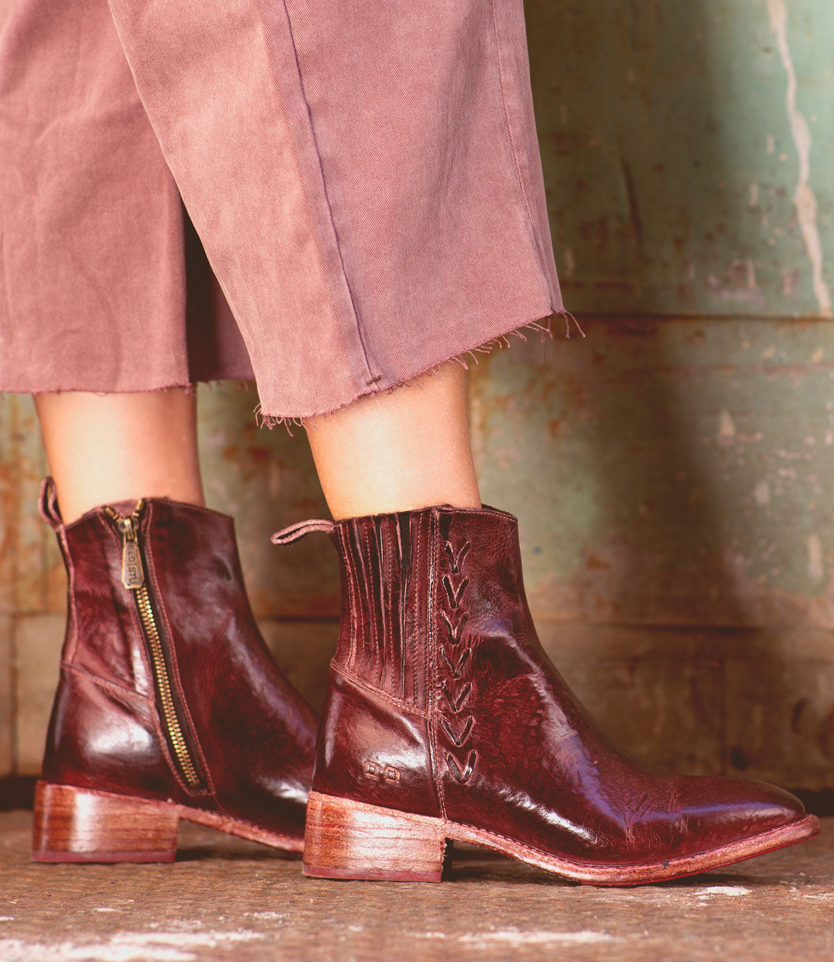 A woman wearing a pair of Bed Stu Alina burgundy leather ankle boots in the city.