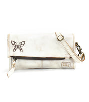 A sleek white leather Bed Stu clutch with a butterfly on it.