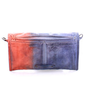 A small, rectangular, gradient leather crossbody clutch with magnetic flap and wrist strap, transitioning from orange to blue, the Amina by Bed Stu.