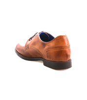The Bed Stu Anchiano, a brown leather oxford dress shoe with a black sole, is shown from the back left angle, highlighting heritage craftsmanship against a white background.