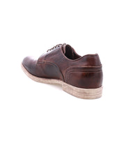 Anchiano by Bed Stu: a worn brown oxford shoe with distressed leather and a scuffed, flexible sole, displayed at an angle on a white background.