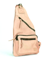 The Bed Stu Andie is a pink leather sling bag with multiple compartments and zippers, offering practical style. With its triangular shape and top handle, it's a versatile accessory perfect for any occasion.