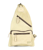 The Andie by Bed Stu is a versatile beige triangular leather sling bag featuring two zippered pockets and an adjustable strap, making it an ideal practical accessory for any outing.