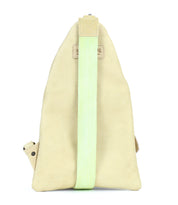 The Andie by Bed Stu is a beige triangular sling bag featuring a single light green strap, buttoned flap, and leather accents—making it the perfect versatile accessory for any occasion.
