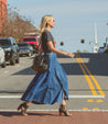Woman crossing the street on a sunny day while wearing a denim skirt and Bed Stu Angelique II leather heeled peep-toe boots.