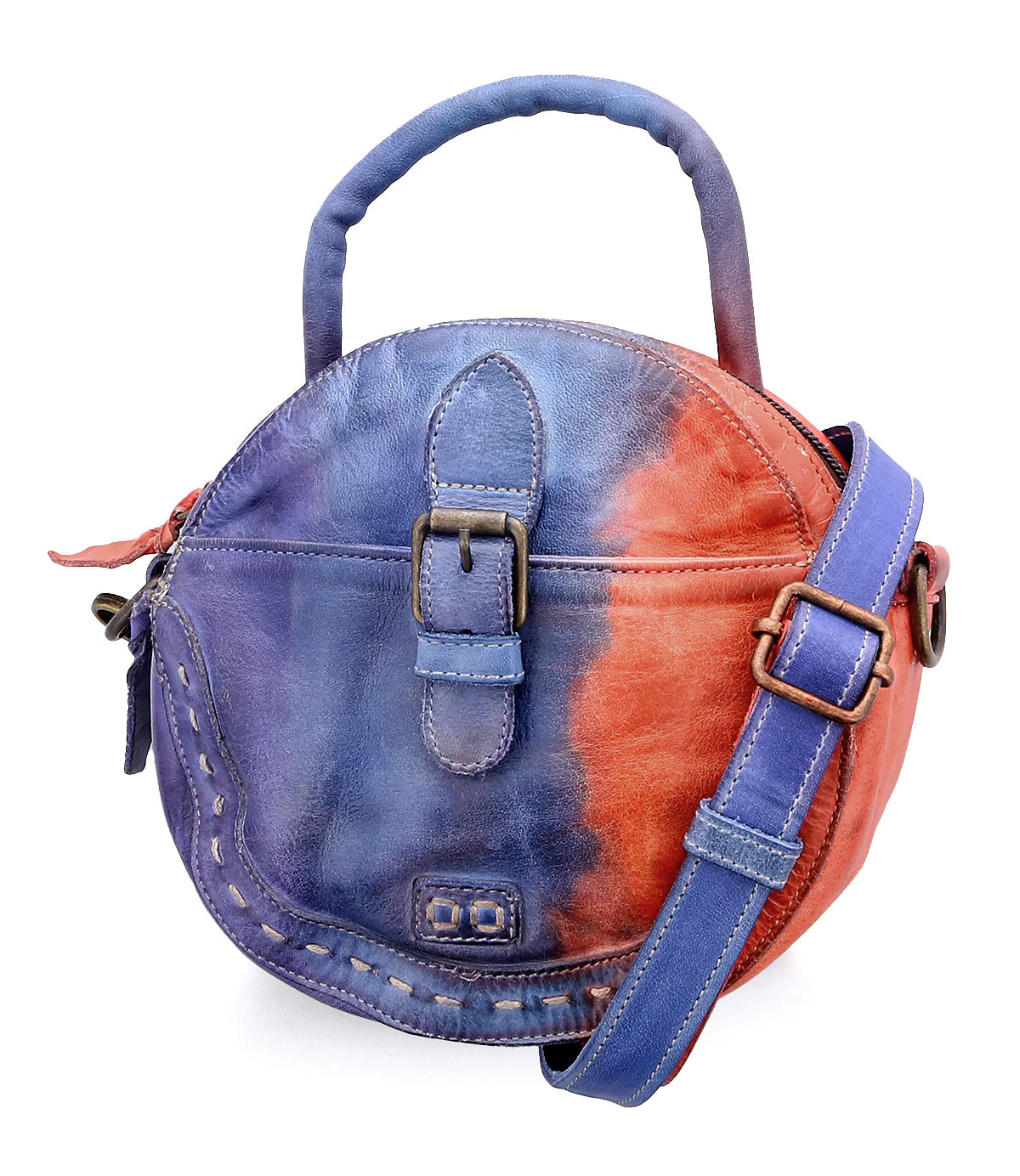 The Bed Stu Arenfield is a compact round leather handbag featuring a blue and red tie-dye pattern, top handle, buckle detail, and an adjustable strap for versatile crossbody wear.