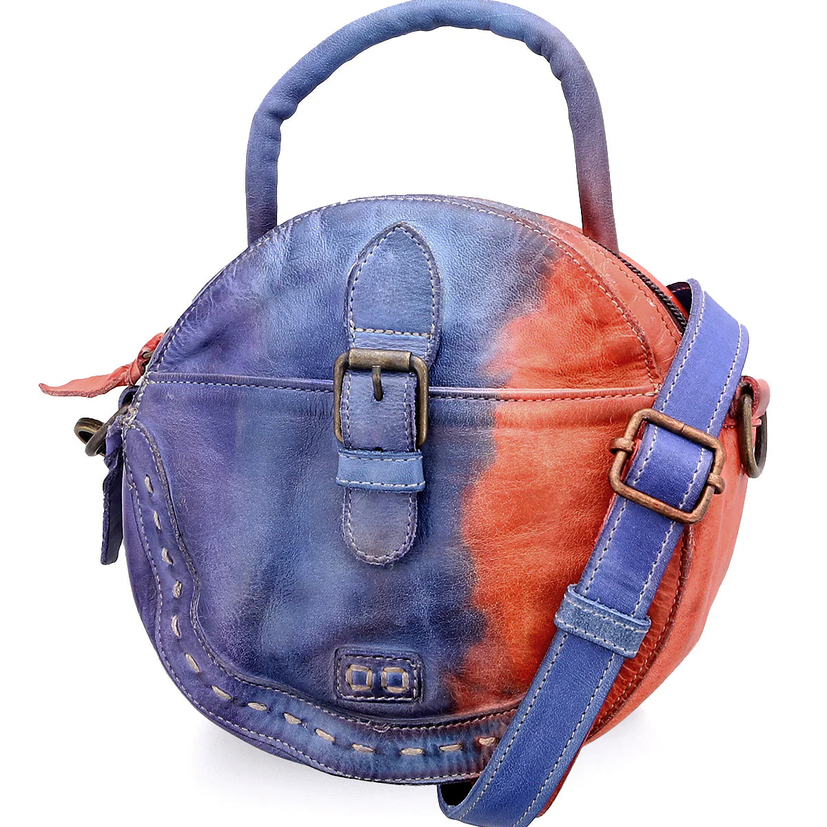 The Bed Stu Arenfield is a compact round leather handbag featuring a blue and red tie-dye pattern, top handle, buckle detail, and an adjustable strap for versatile crossbody wear.