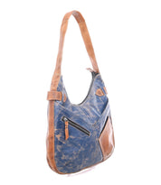 The Bed Stu Argus is a handcrafted leather shoulder bag in distressed blue and brown, with an oversized zippered front pocket and adjustable strap, shown on a white background.