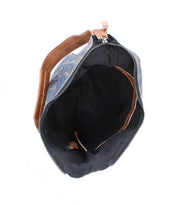 Open top view of the empty Bed Stu Argus blue and brown patchwork leather bag featuring a black interior, zipper closure, and oversized front pockets.