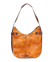 The Bed Stu Argus is a handcrafted brown leather shoulder bag with a wide strap, side buckle accents, and oversized front pockets, shown on a white background.