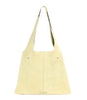 The Ariel II by Bed Stu is a beige hobo bag featuring a slim shoulder strap and front pocket detailing, designed for minimalist function. Its spacious main compartment offers ample room, all showcased against a plain white background.