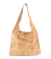 The Ariel II by Bed Stu is a tan leather tote bag with a wide, sloping strap and visible front stitching. It has a spacious compartment, embracing minimalism while prioritizing practicality.