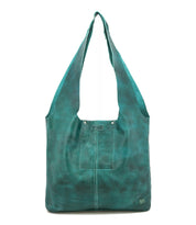 The Ariel Max by Bed Stu is a teal artisanal bag with a front pocket and wide straps, crafted from hand-finished leather and displayed upright against a white background.