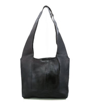 The Bed Stu Ariel Mid is a black artisanal leather bag with a wide strap, magnetic closure, and simple minimalist design—crafted for everyday function.