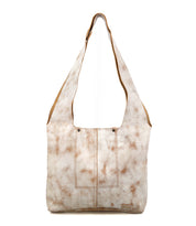 The Bed Stu Ariel Mid is a large tan and white tie-dye shoulder bag with two front pockets, a wide strap, and a magnetic closure, shown against a white background.