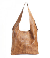 The Bed Stu Ariel EM is a large, tan leather minimalist bag featuring a wide strap and embossed swirl pattern, shown upright against a white background.