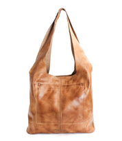 The Bed Stu Ariel EM is a limited edition large brown leather tote bag with a wide shoulder strap and front pocket, shown on a white background. This minimalist design blends style and functionality for everyday use.