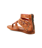 The Bed Stu Artemis II is a brown leather gladiator sandal featuring multiple straps and a side zipper, shown at an angle to highlight the stylish back and side of this thong sandal.