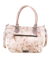 The Bed Stu Astana is a beige marbled modern handbag with two handles, a detachable shoulder strap, and a front zippered pocket, styled like a vintage bowling bag and shown on a white background.