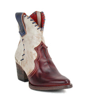 The Bed Stu Baila II is a Western-inspired women's cowboy boot featuring a maroon pointed toe and heel, cream shaft, blue accents, decorative stitching, medium stacked heel, and artisanal craftsmanship.