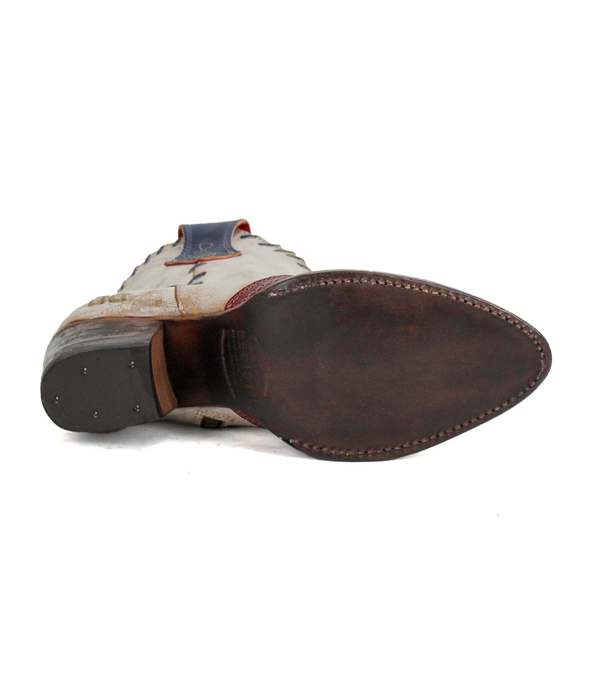 The Bed Stu Baila II boot is displayed sole-up, showcasing its pointed toe, smooth leather outsole with visible stitching, and heel nails—a testament to artisanal Western-inspired craftsmanship.