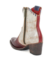 The Bed Stu Baila II is a women's ankle boot featuring a pointed toe, side zipper, red and white leather panels, blue stitching, artisanal construction, and a stacked wooden heel.