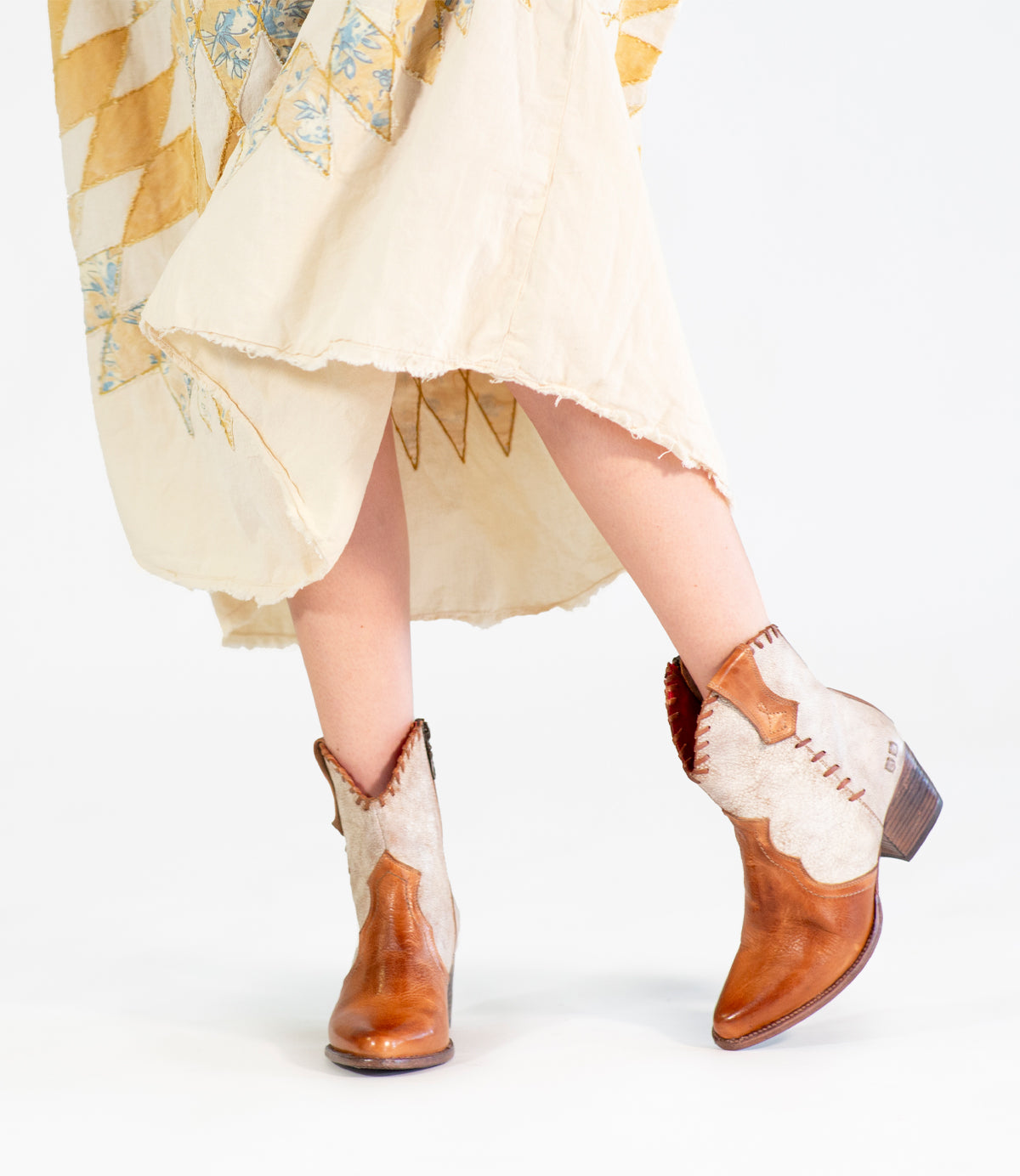 A woman in a dress and cowboy boots exudes Baila II cowgirl vibes from Bed Stu.