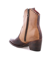 The Baila II ankle boot by Bed|Stü is crafted from two-toned leather with artisanal construction, a pointed toe, and features a side zipper, a dark brown heel, and detailed stitching around the ankle—shown in profile on a white background.