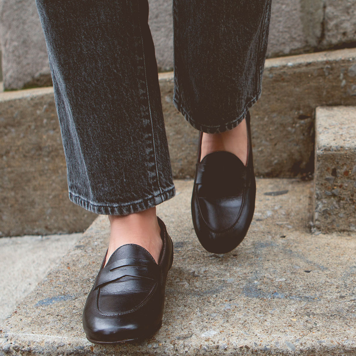 Person sporting Bed Stu Ballet and cuffed jeans, descending concrete steps with an air of comfort and flexibility.