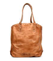 The Bed Stu Barra is a large handmade tan leather tote with double handles, contrast stitching along the edges, and metal rivet accents near the handles.