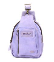The Beau by Bed Stu is a small lavender leather sling backpack with a durable strap, front zipper pocket, main compartment, and a "BED|STU" patch label—ideal for hands-free activities.