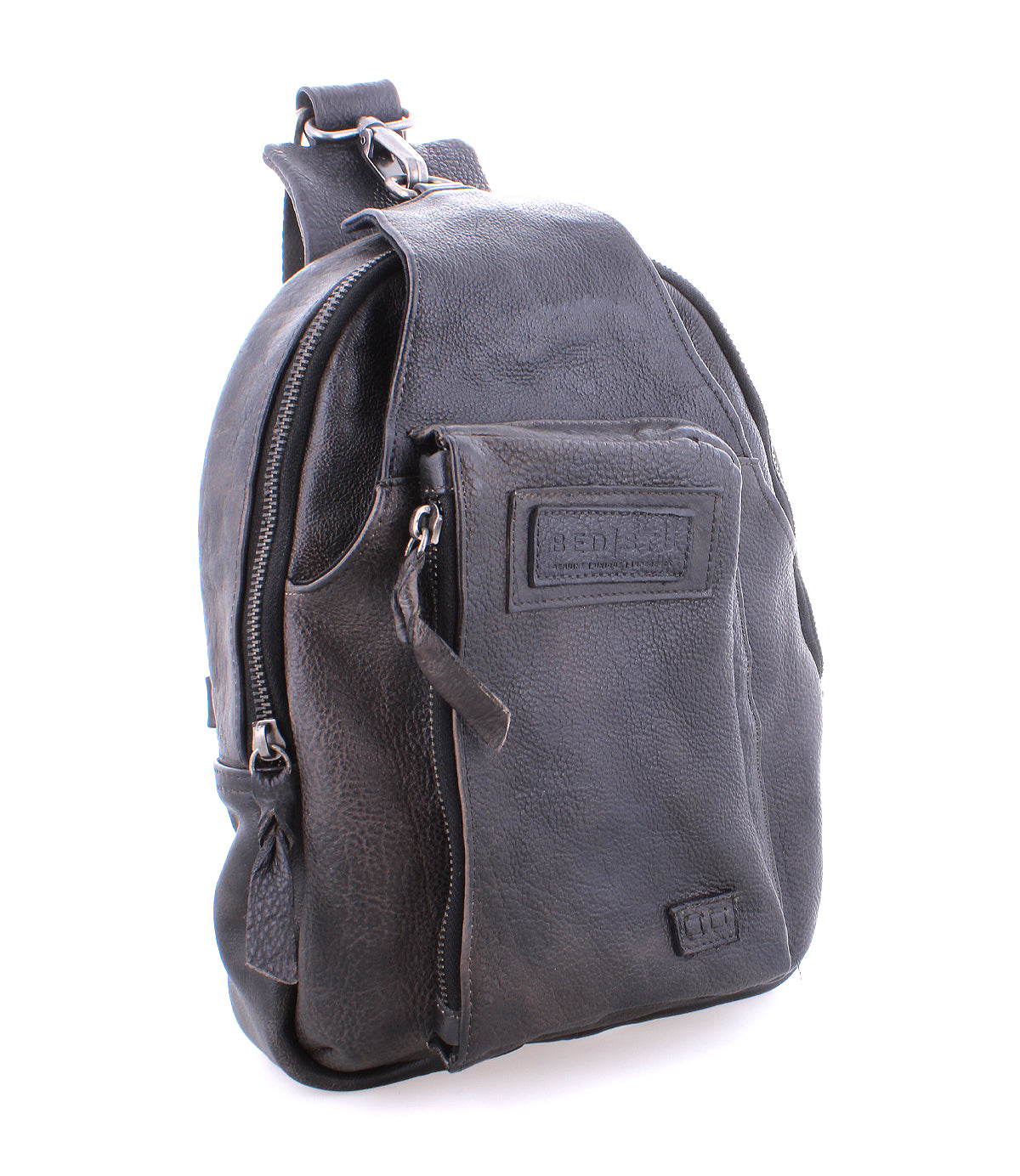 Black leather Beau sling backpack by Bed Stu isolated on a white background.