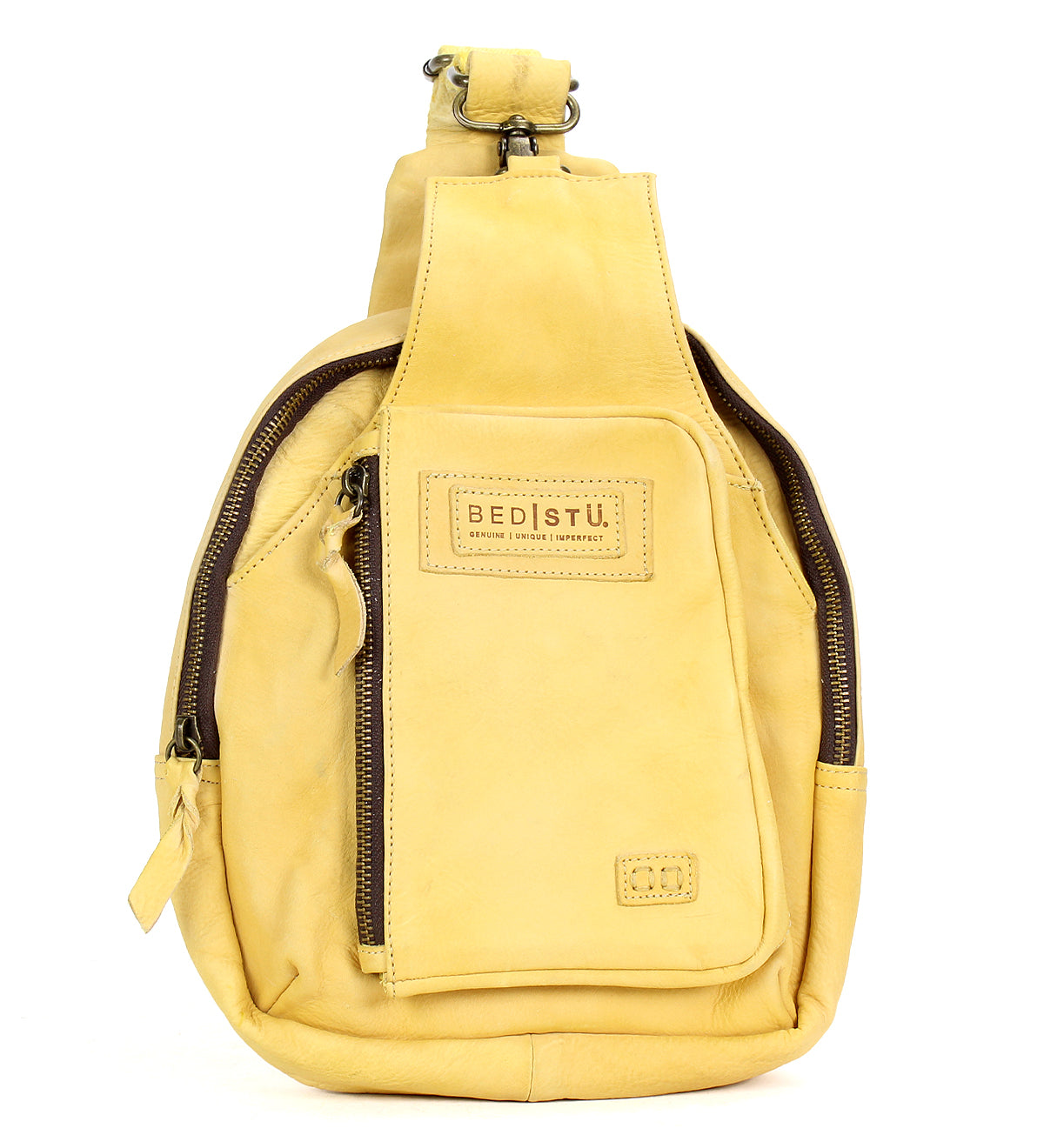 Introducing the Beau by Bed|Stü—a small yellow leather sling bag featuring two zippered compartments and a signature front patch. This compact backpack is ideal for carrying your essentials with stylish ease.