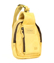 The Beau by Bed Stu is a yellow leather sling backpack featuring multiple zippered pockets, a durable strap for hands-free use, and the Bed Stu label on the front.
