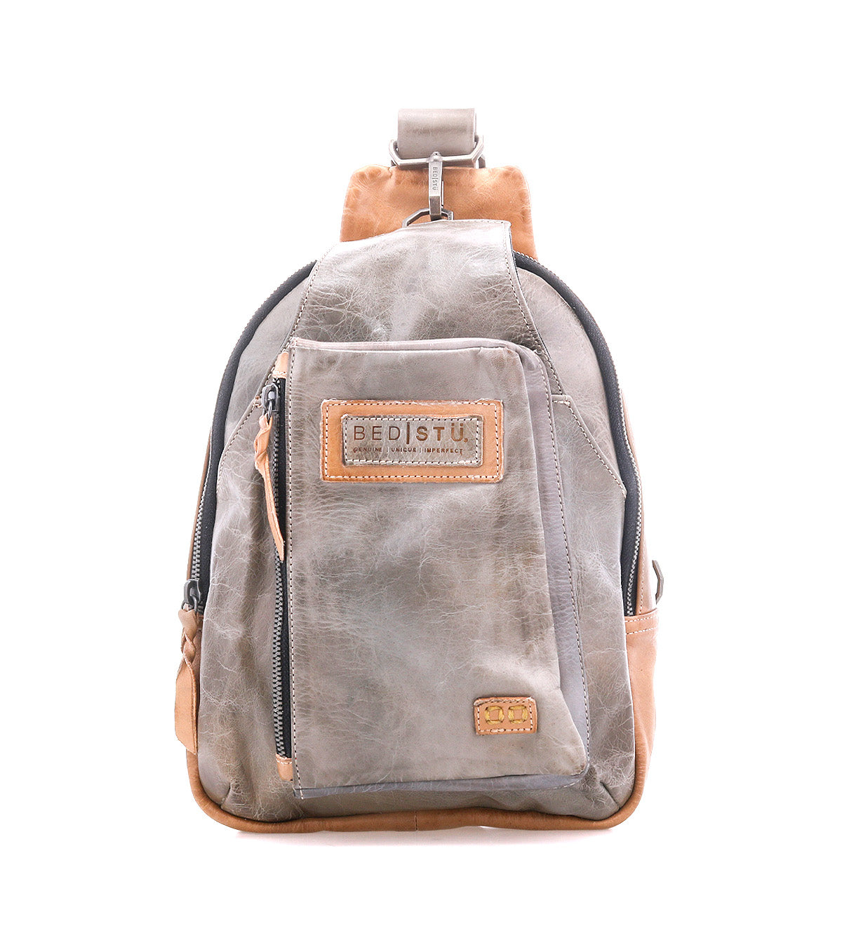 The Beau backpack by Bed|Stü is a small sling bag in gray and brown leather, featuring a front zip pocket, a top handle, and the brand's signature label, shown against a white background.