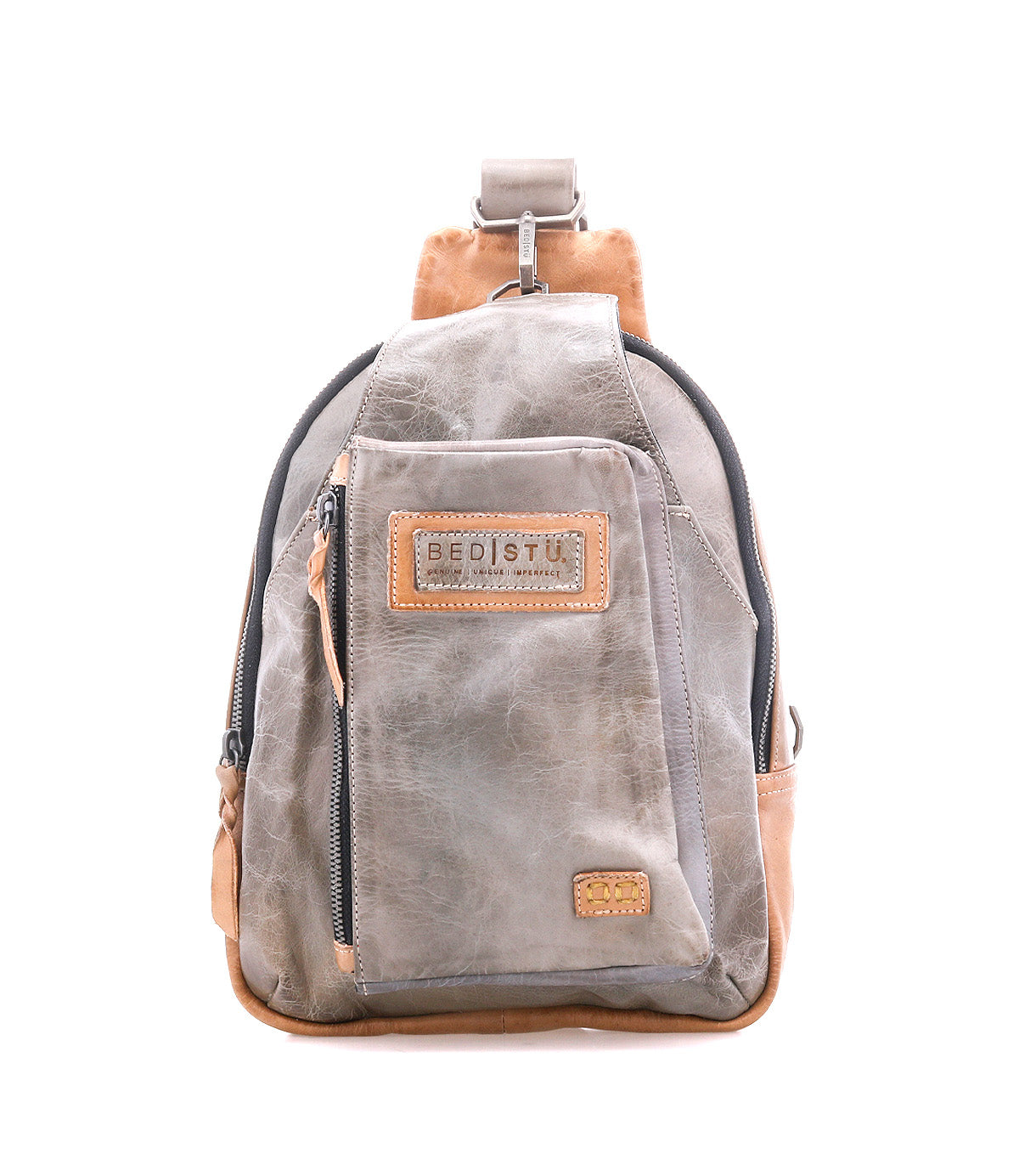 The Bed Stu Beau is a gray and tan leather sling backpack featuring a front zip pocket and stitched logo patch—a versatile unisex bag for hands-free carrying, displayed against a white background.