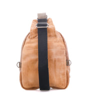 The Beau by Bed Stu is a tan leather sling backpack with a black adjustable strap, shown from the back on a white background. This hands-free bag offers style and convenience for everyday use.