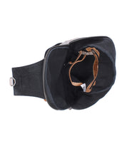 Top view of the Bed Stu Beau, an open black unisex backpack with a zipper, showing its empty interior and a single small tan strap inside.