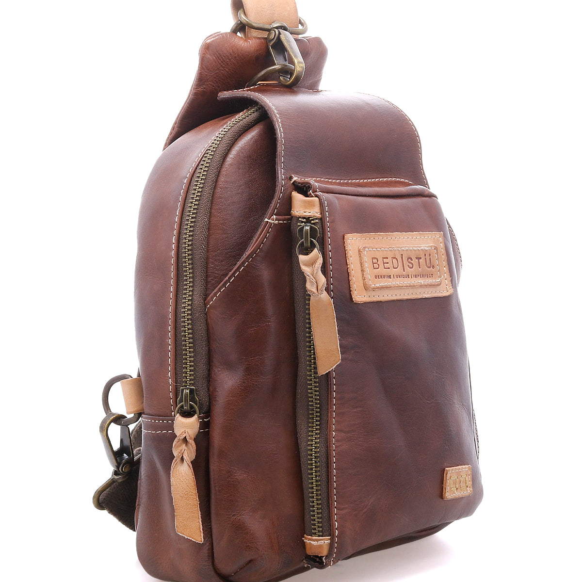 The Bed Stu Beau crossbody bag features brown leather, beige stitching, zippered compartments, and a "Bed Stu" patch on the front—an ideal everyday accessory for stylishly carrying your essentials.