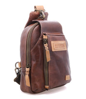 The Bed Stu Beau crossbody bag features brown leather, beige stitching, zippered compartments, and a "Bed Stu" patch on the front—an ideal everyday accessory for stylishly carrying your essentials.